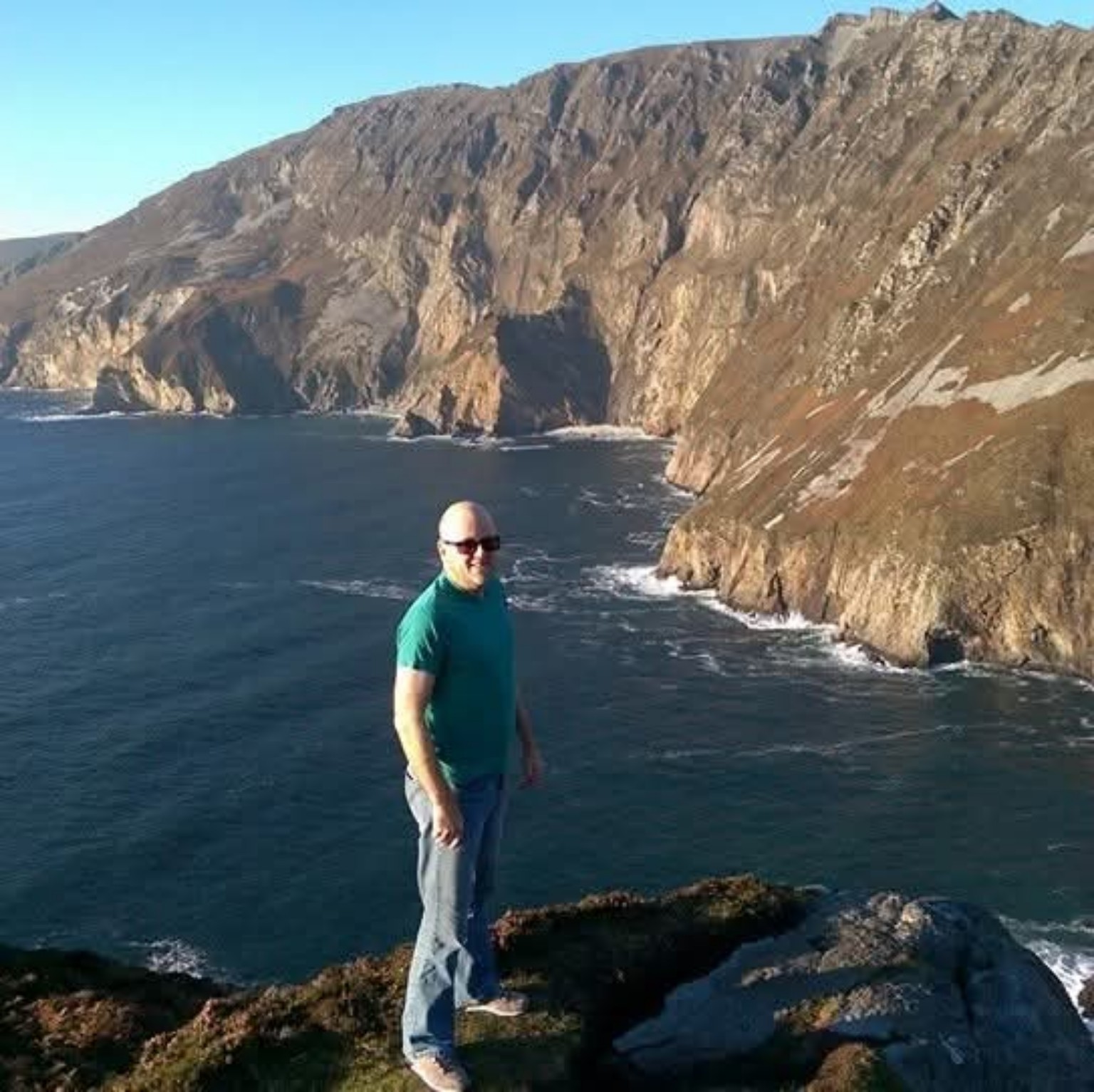 Mark standing above the sea against a dramatic coastal landscape