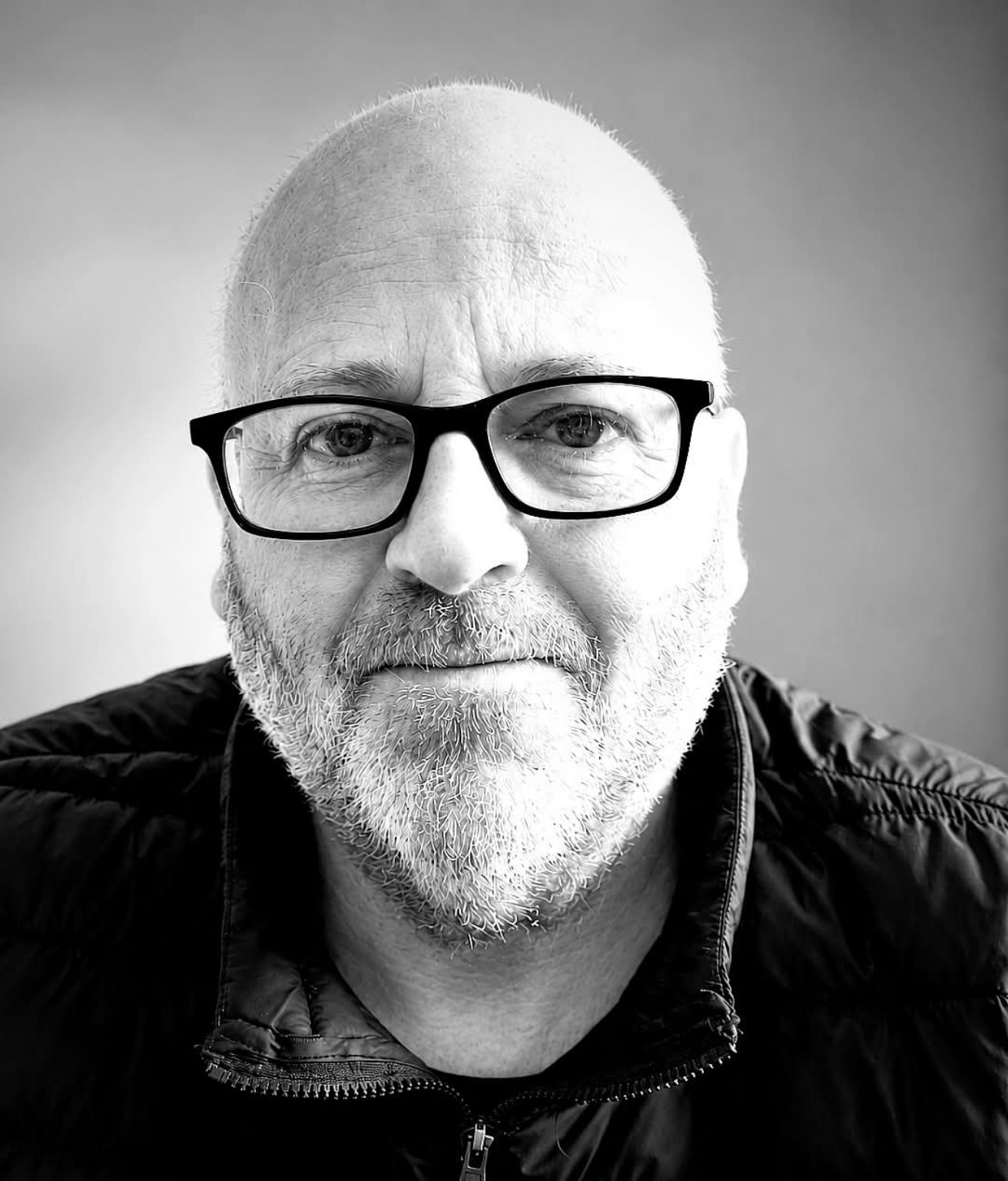Black-and-white portrait of Mark McCollum wearing dark-framed glasses
